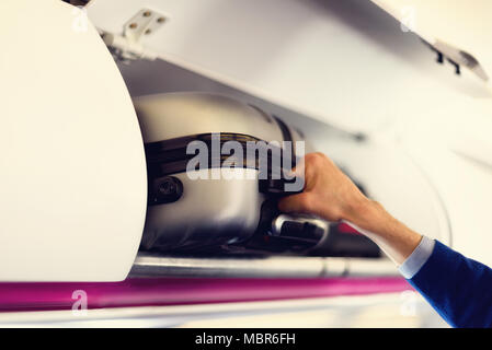 Hand - Gepäckraum mit Koffern in Flugzeug. Hände weg von Handgepäck. Passagier, Handgepäck Kabine auf dem obersten Regal. Travel Concept mit kopieren. Stockfoto