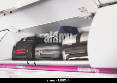 Hand - Gepäckraum mit Koffern in Flugzeug. Handgepäck auf dem obersten Regal der Ebene. Travel Concept mit Kopie Raum Stockfoto