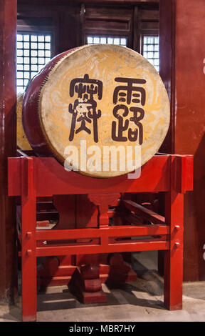 Peking, China - 26. April 2010: Nahaufnahme von historischen gelb-braun Drum auf rotem Sockel für den Drum Tower. Mandarin Zeichen. Stockfoto