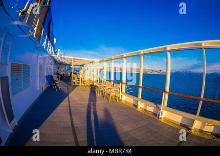 ALESUND, Norwegen - 09 April, 2018: im Blick auf die Menschen und die Aussicht genießen während einer Hurtigruten Kreuzfahrt Reise, von Deck in ein prachtvoller blauer Himmel und blaue Wasser Stockfoto