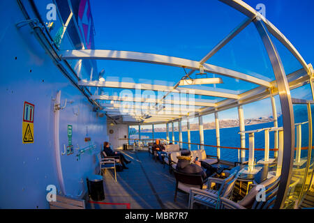 ALESUND, Norwegen - 09 April, 2018: im Blick auf die Menschen und die Aussicht genießen während einer Hurtigruten Kreuzfahrt Reise, von Deck in ein prachtvoller blauer Himmel und blaue Wasser Stockfoto