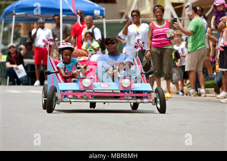 Ein Vater und eine Tochter ihre hausgemachten Auto unten einer hügeligen Straße im kühlen Vatis Rock Soap Box Derby lenken, am 3. August 2013 in Atlanta, GA. Stockfoto