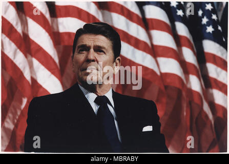 Präsident Ronald Reagan spricht vom Präsidentenpalast Podium vor eine Reihe von amerikanischen Flaggen Stockfoto