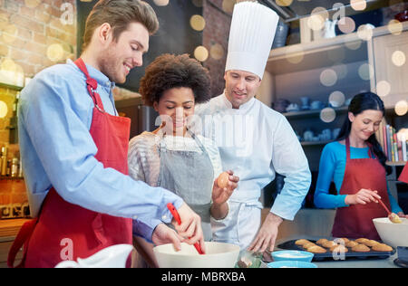 Glückliche Freunde und Chef-Koch Küche Backen Stockfoto