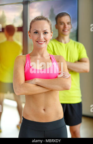 lächelnder Mann und Frau im Fitness-Studio Stockfoto