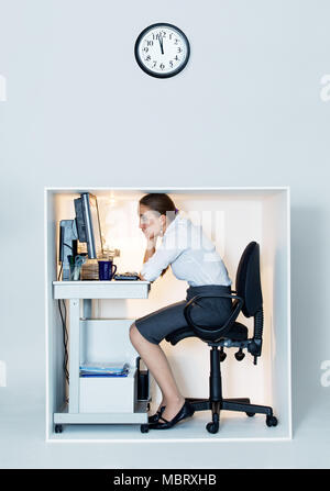 Frau in winzigen Bürozelle arbeiten Stockfoto