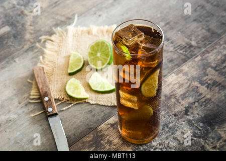 Cuba Libre. Cocktail mit Rum, Limetten und Eis auf hölzernen Tisch Stockfoto