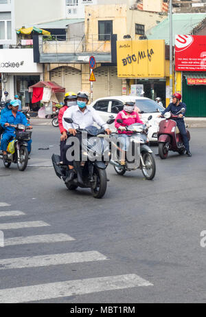 Motorradfahrer, viele tragen Gesichtsmasken, Reiten Ihre Motorräder auf den Straßen von Ho Chi Minh City, Vietnam. Stockfoto