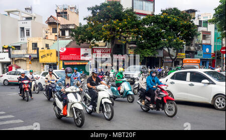 Motorradfahrer, viele tragen Gesichtsmasken, Reiten Ihre Motorräder auf den Straßen von Ho Chi Minh City, Vietnam. Stockfoto