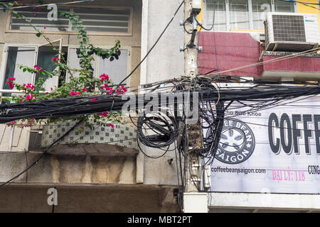 Elektro- und Telefonkabel auf Strommasten in Ho Chi Minh City, Vietnam verheddert. Stockfoto