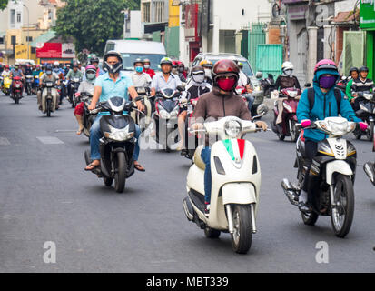 Motorradfahrer, viele tragen Gesichtsmasken, Reiten Ihre Motorräder auf den Straßen von Ho Chi Minh City, Vietnam. Stockfoto