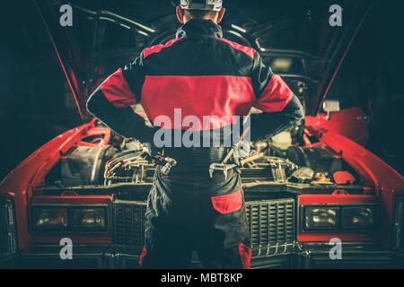 Oldtimer Reparatur Herausforderung. Klassische Automechaniker mit Werkzeugen vor Oldtimer Vorbereitung für seine Arbeit zu erhalten, den Motor starten. Stockfoto