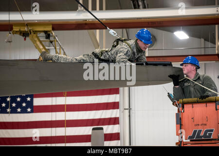 Master Sgt. Anthony Oprean hilft älteren Flieger Mason Frasher der Aufzug auf der Schwanz einer C-130H Hercules installieren Wie es ist wieder nach Reparaturen an Jan. 5, 2018, an der 179th Airlift Wing, Mansfield, Ohio. Die 179Th Airlift Wing Maintenance Group prüft regelmäßig, alle Aspekte ihrer Flugzeuge mission Bereitschaft mit bereit Flieger und Flugzeuge bereit zu halten. (U.S. Air National Guard Foto von Tech. Sgt. Joe HarwoodReleased) Stockfoto