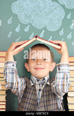 Freundliche Schule Konzept mit dem jungen Joker, die Häute von schlechtem Wetter unter einem Dach aus dem Lehrbuch Stockfoto