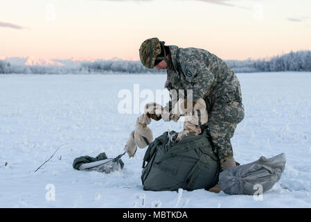 Armee Pvt. Conner Langley, ein Eingeborener von Baton Rouge, La., der 6. Brigade Engineer Battalion, 4th Infantry Brigade Combat Team (Airborne), 25 Infanterie Division, U.S. Army Alaska, erholt sich sein Fallschirm nach Abschluss eine zerstreute Ausbildung springen auf malemute Drop Zone, Joint Base Elmendorf-Richardson, Alaska, Jan. 9, 2018. Die Soldaten der 4/25 gehören zu den nur American Airborne Brigade im Pazifik und sind geschult in der Luft Manöver bei extrem kalten Wetterbedingungen/Höhe Umgebungen zur Unterstützung der Bekämpfung, Ausbildung und Katastrophenhilfe Operationen auszuführen. (U.S. Air Force Foto von Stockfoto