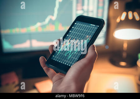 Männliche hand Smartphone mit online mobile App zeigt die Grafik auf der Anzeige, Händler Investor mit Phone Application für Lager tradi Stockfoto