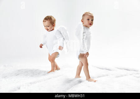 Zwei fröhliche Baby Engel auf dem weichen Teppich Stockfoto