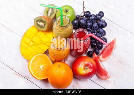 Frische Säfte Smoothie drei Flaschen Rot Grün Orange tropische Früchte Wassermelonen Apple Kiwi Trauben Orange Mango Ananas Granatapfel Traube Selektive Stockfoto