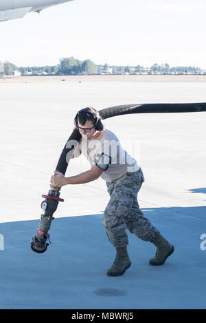 Papst Army Airfield, N.C. - Senior Airman Kyle König, ein Brennstoffe Techniker in der 43d Air Base Squadron, trägt ein Schlauch von einer Betankung Stapler nach einem 437Th Airlift Wing C-17 Globemaster III, während bei der Unterstützung der gemeinsamen airdrop Ausbildung auf Grün Rampe hier Jan. 10, 2018. Die 43 d-Air Mobility Operations, die Teil des Air Mobility Command, unterstützt die Luftbrücke Schulung und reale Vorgänge für Armee und Luftwaffe konventionelle und Special Operations Units in Fort Bragg, bewegen Millionen von Pfund an Fracht und Tausende von Passagieren pro Jahr. Stockfoto