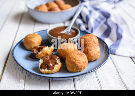 Bunuelos - traditionelle kolumbianische Süßes frittiertes Gebäck mit Schokolade Soße serviert. Stockfoto