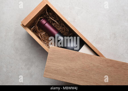 Cabernet Wein Box: Eine einzelne Flasche Rotwein in einem Holz, teilweise durch sein Deckel abgedeckt. Stockfoto