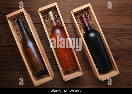 Drei Wein Boxen: Erröten, Cabernet und Chardonnay Wein Flaschen in einzelnen Fällen mit Verpackung Stroh. Stockfoto