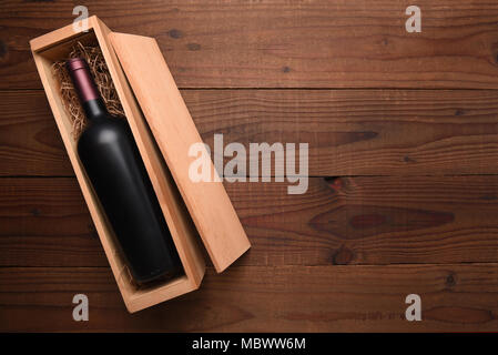 Cabernet Wein Box: Eine einzelne Flasche Rotwein in der Holzkiste auf einem dunklen Holztisch mit kopieren. Stockfoto