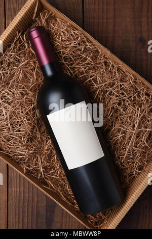 Cabernet Wein Flasche in Verpackung Stroh: High Angle Shot einer einzigen Flasche mit leeres Etikett in einem Karton mit Strohhalm packen. Stockfoto