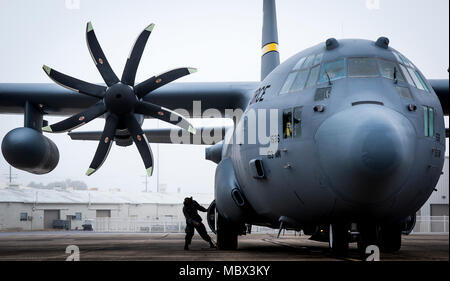 Ein 153 Airlift Wing Betreuer Orte Bremsklötze an den Rädern einer C-130 H nach der Ankunft in Eglin Air Force Base, Fla., Jan. 11. Luftwaffe erste voll aufgerüstet C-130H ist hier für Test und Evaluierung auf die neue modifizierte Propeller und Motoren. (U.S. Air Force Foto/Samuel King Jr.) Stockfoto