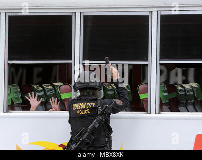 Quezon City, Philippinen. 12 Apr, 2018. Ein Mitglied der spezielle Waffen und Taktiken der Philippinischen Nationalpolizei (PNP-SWAT) beteiligt sich an einer Simulation an der Anti-terror- und Krisenmanagement in Quezon City, Philippinen, 12. April 2018. Die PNP und die Streitkräfte der Philippinen durchgeführt, um die Anti-terror-übung ihre Fähigkeiten im Umgang mit den Bedrohungen durch Terrorismus, Geiselnahme, um zu zeigen, und die Bombe Krisen. Credit: rouelle Umali/Xinhua/Alamy leben Nachrichten Stockfoto