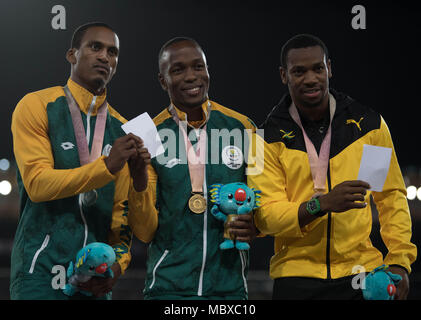 Gold Coast, Queensland, Australien. 10 Apr, 2018. Goldmedaillenträger Südafrikas Akani Simbine wirft mit silbermedaillengewinner Südafrikas Henricho Bruintjies (L) und Bronze Der medaillenträger Jamaika Yohan Blake (R) Während der Leichtathletik Männer 100 m-finale Siegerehrung Während der Commonwealth Games 2018 Gold Coast an der Carrara Stadion. Credit: Ben Stand/SOPA Images/ZUMA Draht/Alamy leben Nachrichten Stockfoto