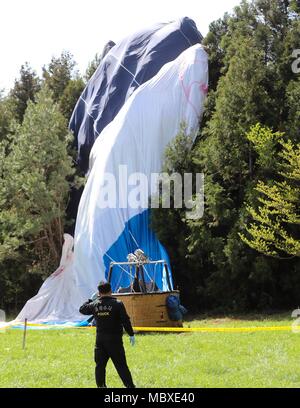 In Jeju, Südkorea. 12 Apr, 2018. Ein Polizist arbeitet auf der Website von einem Heißluftballon crash auf der Insel Jeju, Korea, 12. April 2018. Ein Mensch getoetet und 12 andere in einem Heißluftballon verletzt worden bei der Landung frühen Donnerstag. Credit: Newsis/Xinhua/Alamy leben Nachrichten Stockfoto