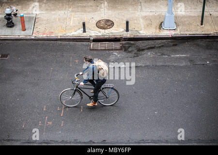 NEW YORK CITY - 29. MÄRZ 2018: New York City, Manhattan Street Scene von oben betrachtet mit Mann, Fahrrad und Fußgänger von Chelsea gesehen. Stockfoto