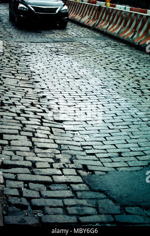 Alte New York City Straße mit Kopfsteinpflaster mit Asphalt repariert Stockfoto