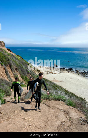 Surfer klettern auf dem Weg zum Strand an der Küste des südlichen Kalifornien in der Nähe von Malibu nach einem Morgen des Surfens. Stockfoto