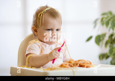 Adorable einjährigen Baby versuchen, eine Pasta zu fangen Stockfoto