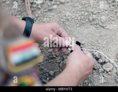 Eine irakische Terrorismusbekämpfung Service die Beseitigung von Explosivstoffen student Rigs einer strahlkabine Kappe zu Sprengstoff aus einem ISIS-Cache während einer Übung im Bagdad diplomatische Unterstützung komplexer beschlagnahmt detonieren, 28. März 2018. Koalition Mitglieder waren vor Ort zu helfen, beraten und CTS mit der richtigen Beseitigung von explosionsfähigen Kriegshinterlassenschaften, um ihre Fähigkeiten zu verbessern und die Stabilität und Normalität in den Irak bringen. Stockfoto