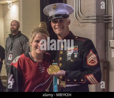 Staff Sgt. Sean Kaspar, ein Unteroffizier mit einziehenden Station Phoenix, wirft mit Brianna Decker, einem Mitglied der US-amerikanischen Frauen National Hockey Team, während einer Arizona Kojoten hockey Spiel auf März 31,2018 am Gila River Arena, Glendale, Ariz., AZ. Kaspar war der Service Mitglied des Spiels genannt. Stockfoto