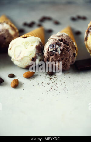 Schokolade und Kaffee Eis in der Waffel Kegel mit Kaffeebohnen auf grauem Stein. Sommer essen Konzept, kopieren. Gesund glutenfreie Eis. Ansicht von oben Stockfoto