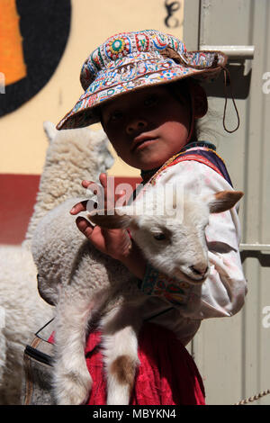 Ein kleines Mädchen präsentiert stolz ihr Baby Lamm und Baby Llama auf die Kamera Stockfoto