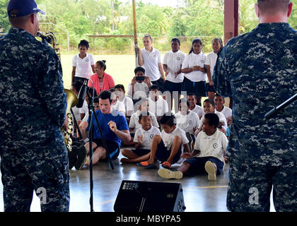 KOROR, Republik Palau (4. April 2018) Britische Armee Cpl. Darren Phillips (blaues Hemd) Tänze mit örtlichen Schule Kinder während einer Performance aus dem US Pacific Command's Deep Six Brass Band während der Teilnahme an Pazifische Partnerschaft 2018 (PP18) Mission stop Palau April 4. PP18's Mission ist es, gemeinsam mit Gastgeber und Partner Nationen zu arbeiten regionaler Interoperabilität und Disaster Response Funktionen, erhöhen die Stabilität und Sicherheit in der Region zu stärken, und neue und dauerhafte Freundschaften in der gesamten indopazifischen Region fördern. Pazifische Partnerschaft, der nun in seinem 13. Iteration, ist die larges Stockfoto