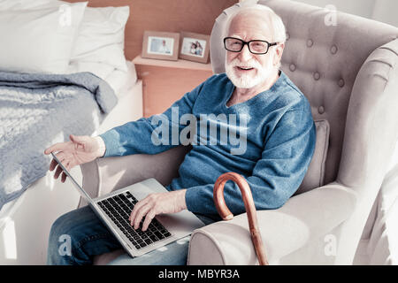Happy bärtiger Mann mit einem Notebook Stockfoto