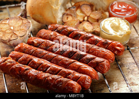 Gegrillte Würstchen mit Sauce Ketchup und Senf auf metall gitter Stockfoto