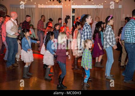 Service für Mitglieder und ihre Töchter nehmen an der Stiefel'n Belles Daddy-Daughter Dance an Marine Corps Air Station Iwakuni, Japan, Jan. 13, 2018. Väter und Töchter tanzten, machte Bilder, Spiele gespielt und gewonnen Gewinnspiel Wettbewerbe, wie sie die Nacht gemeinsam erstellt und Erinnerungen zusammen. (U.S. Marine Corps Foto von Cpl. Gabriela Garcia-Herrera) Stockfoto