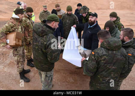 Bobby Hoffmann (5. von rechts), eine Auswahl und Ausbildung Land Programm Spezialist mit der US Army Training Support Aktivität Europa (TSAE) und Soldaten aus Spanien, Slowakei, Kanada, Lettland, Italien und Polen diskutieren ein Tank Bereich trocken Übung in Adazi Training Area, Lettland, Jan. 09, 2018. TSAE führte eine Endkontrolle einer neu gebauten Tank als TSAE ist Unterstützung von NATO-Verbündeten in Osteuropa entwickeln ihre Auswahl und Ausbildung Infrastrukturen. (U.S. Armee Foto von Markus Rauchenberger) Stockfoto