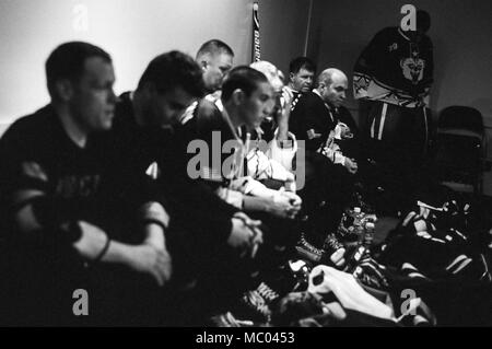 Armee Generalmajor Mark O'Neil, U.S. Army Alaska Commander, dritter von rechts, hört sie einen pep Talk in der Umkleide mit seinem Team zwischen Perioden während der 5. jährlichen Armee gegen Luftwaffe Hockey Game, Jan. 13, 2018, an der Sullivan Arena in Anchorage, Alaska. Das Spiel wird jährlich zwischen Teams aus Service Mitglieder auf die Gemeinsame Basis Elmendorf-Richardson, Alaska zugeordnet gespielt, fördert die militärischen Korpsgeist und verbessert die Beziehung zwischen JBER und die Verankerung der Gemeinschaft. Die Luftwaffe Mannschaft gewann das Spiel 11-1. (U.S. Air Force Foto/Justin Connaher) Stockfoto