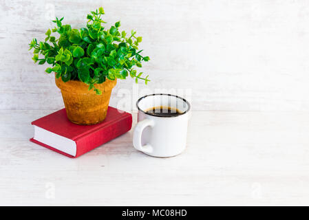 Kleine rote Buch, Kaffeetasse und grüne Blume im rustikalen Keramik Topf. Weiß Holz- Hintergrund, kopieren. Stockfoto