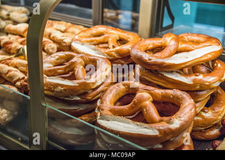 Frisch gebackene Brezeln an einem Schaufenster angeordnet. Stockfoto