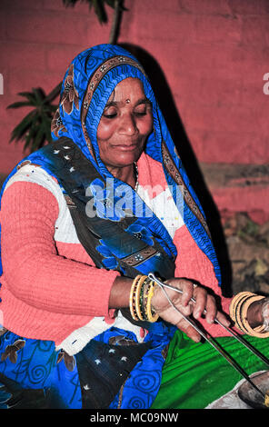 Portrait einer indischen Frau in bunten blauen Sari, Kochen chapati Brot auf einem traditionellen Holzofen Kaminofen (chulha) Stockfoto