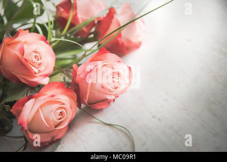 Ein Strauß Rosen auf weißem Holz alte Hintergrund. Vintage-Stil. Stockfoto